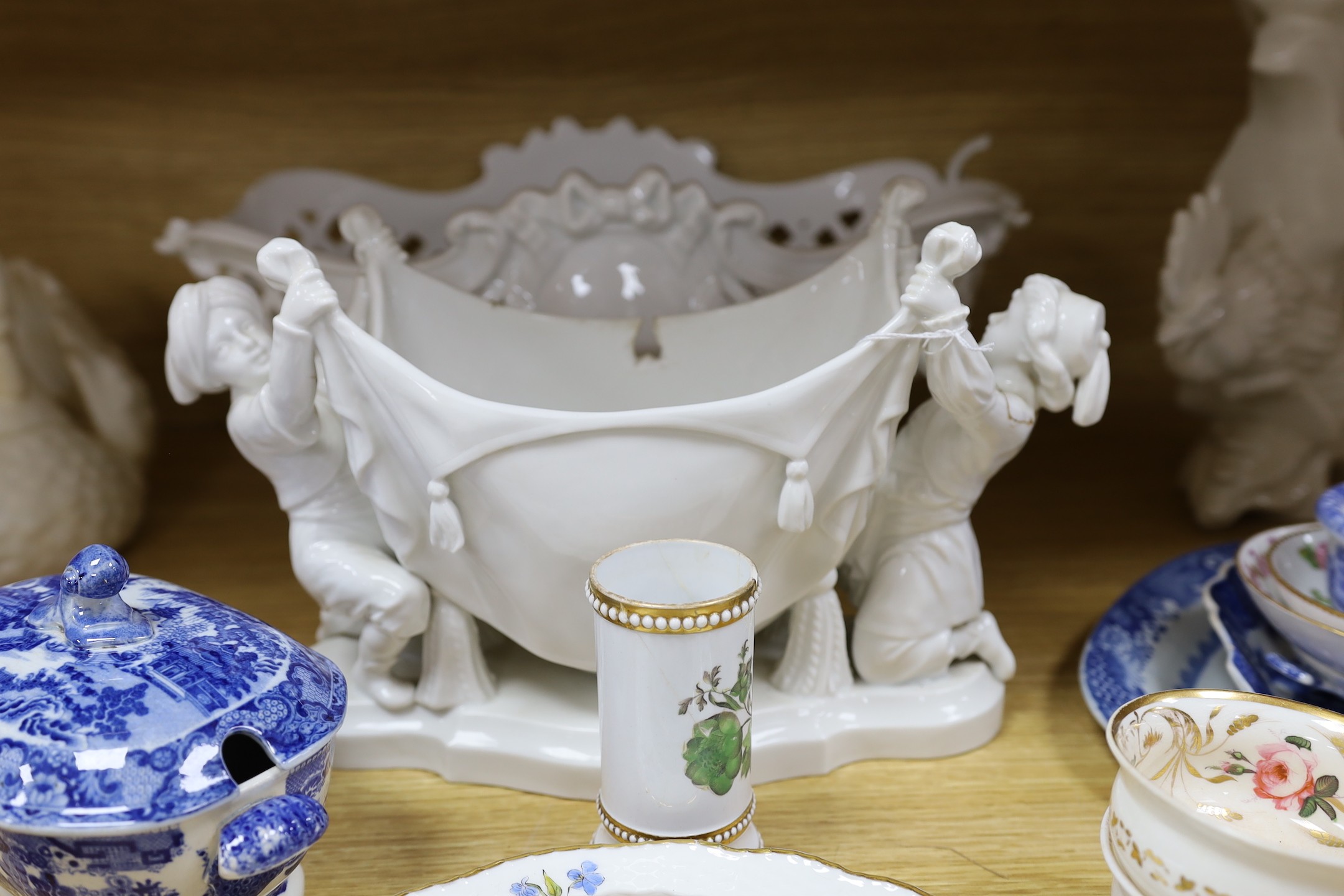 A group of Staffordshire blue and white pottery, including a sauce tureen and cover, together with a selection of decorative tea and dessert wares and ceramic centrepieces, one modelled as a cockerel